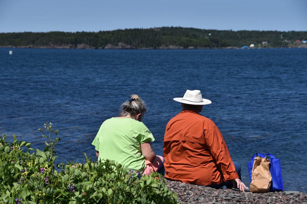 Two community members sitting together looking out over the water
